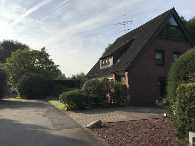 Ein Mehrfamilienhaus, davor ein kleiner Asphaltplatz