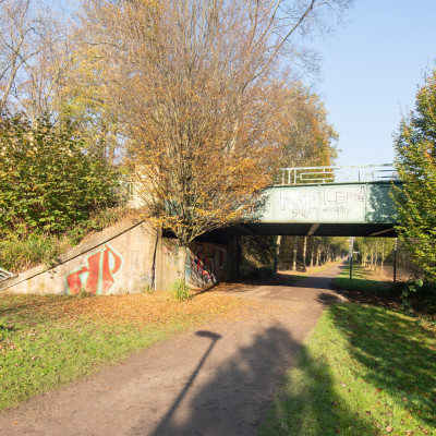 Grüner Fußweg der unter einer Brücke hindurch führt